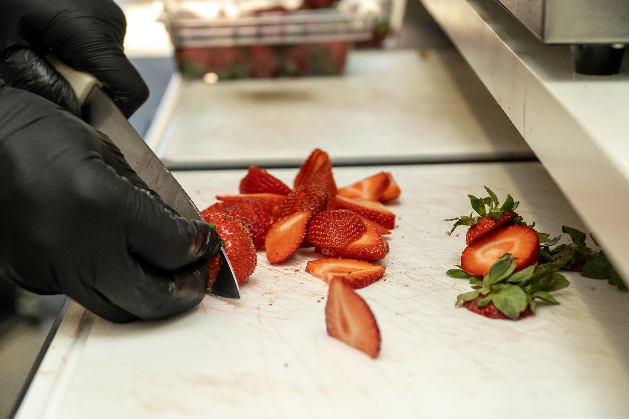  Abood Sluimen slices a strawberry at Zee’s Munchies in San Francisco on March 21, 2026. (Neal Wong / Richmond Review) 