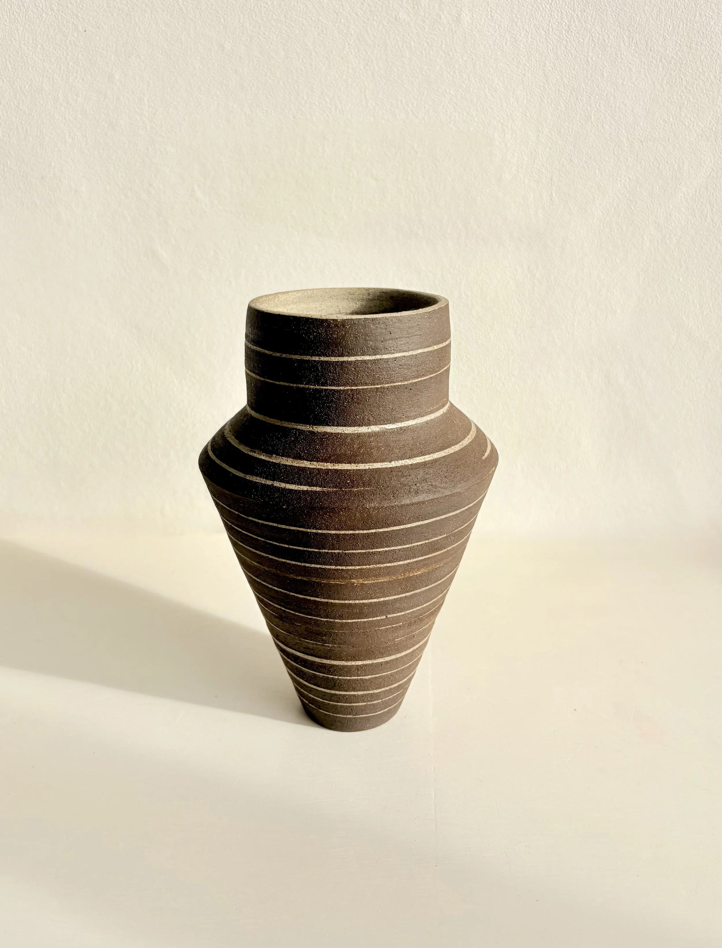 Black clay vase decorated with grey slip inlay lines