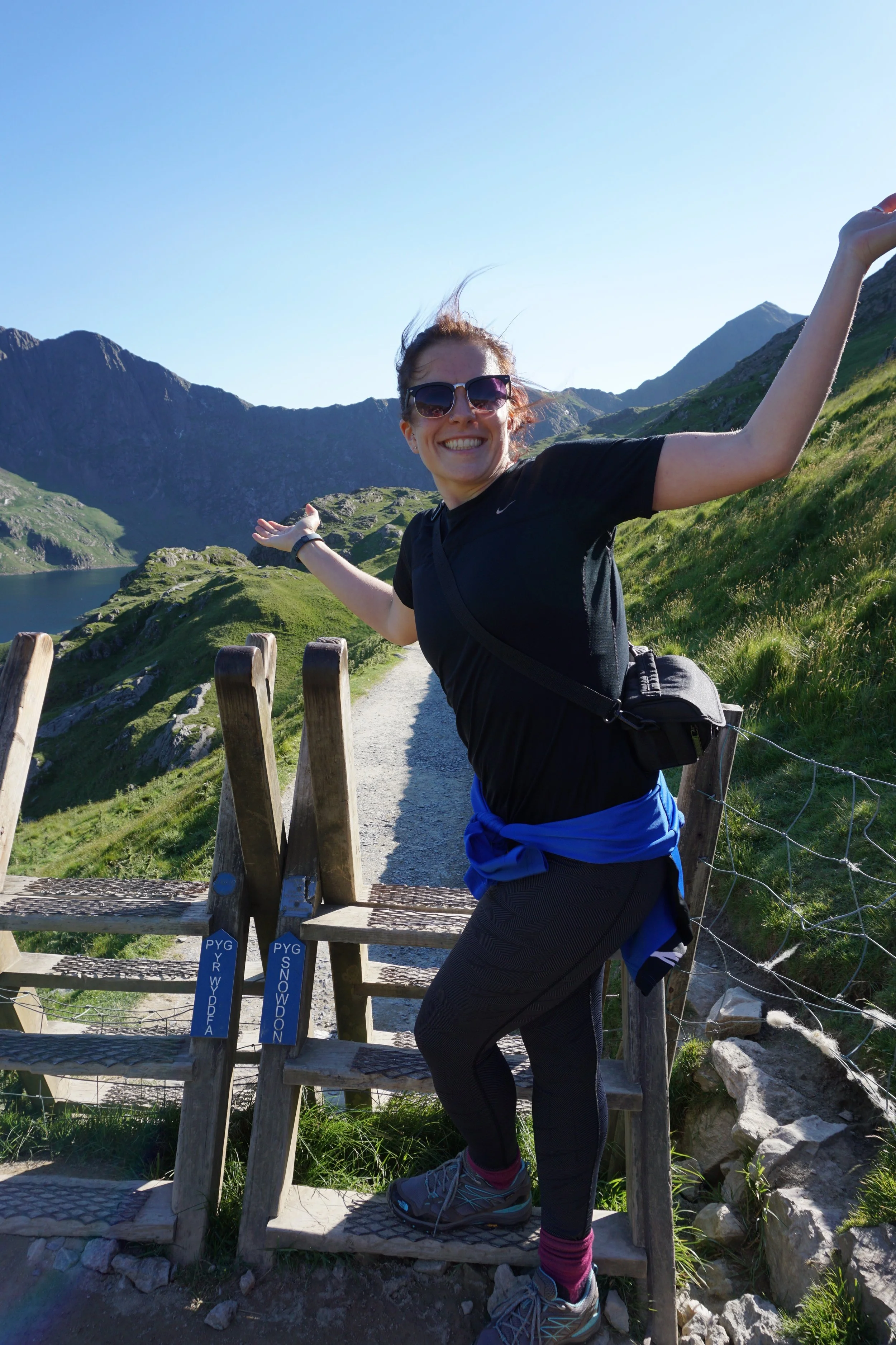 Smiling woman at the bottom of Snowdon ready to climb and embrace her new found fitness.