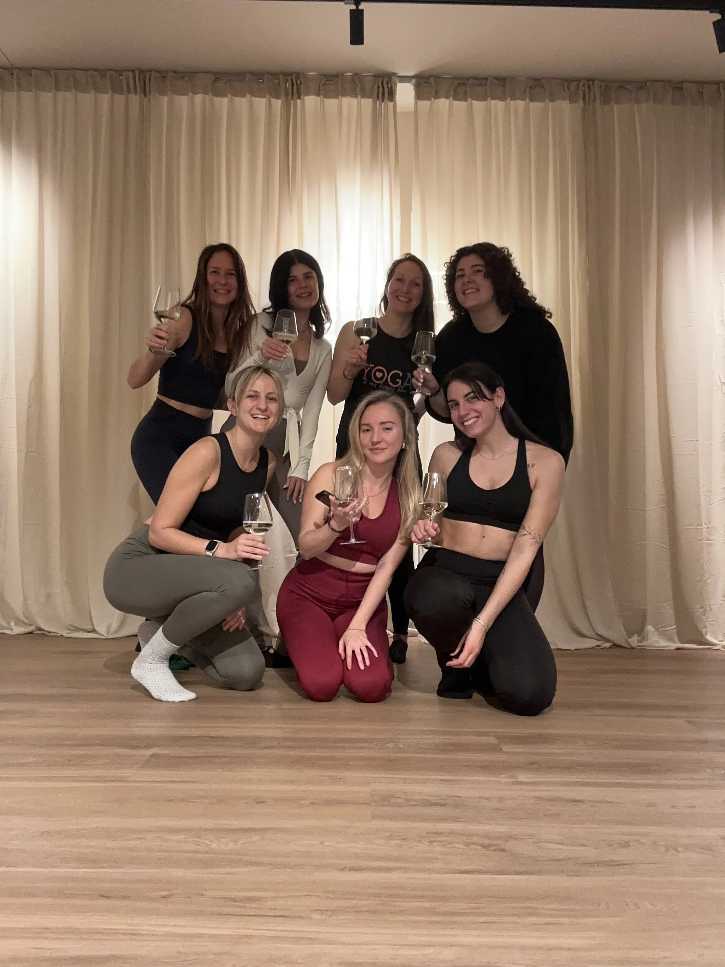 Community Event Pilates und Prosecco. Kleine Gruppe Frauen die die gemeinsame Zeit im Studio genießen.