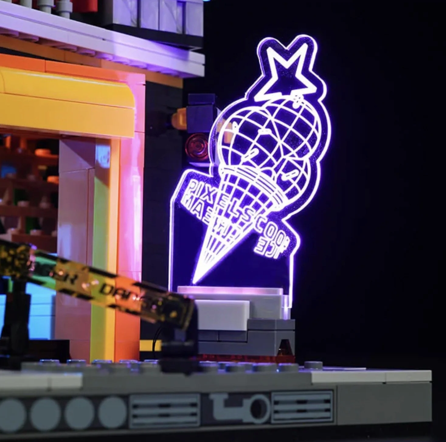 Une enseigne lumineuse en forme de cône de glace avec un globe et une étoile, pour la compétition Lego. La scène inclut des blocs Lego et un décor coloré.