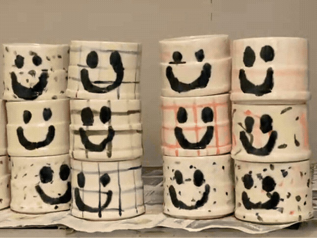 Stacked toilet paper rolls painted with smiley faces.