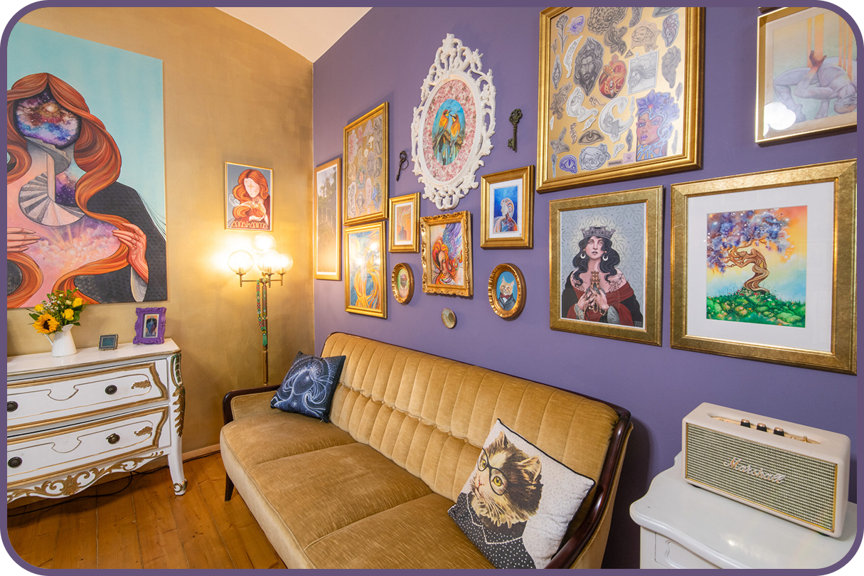 Tatuarium tattoo studio in Vienna, Austria by Annai Anima cozy waiting room with art wall with frames and vintage light bulb and Marshall speaker with vintage velvet sofa. Custom paintings and prints on the wall.