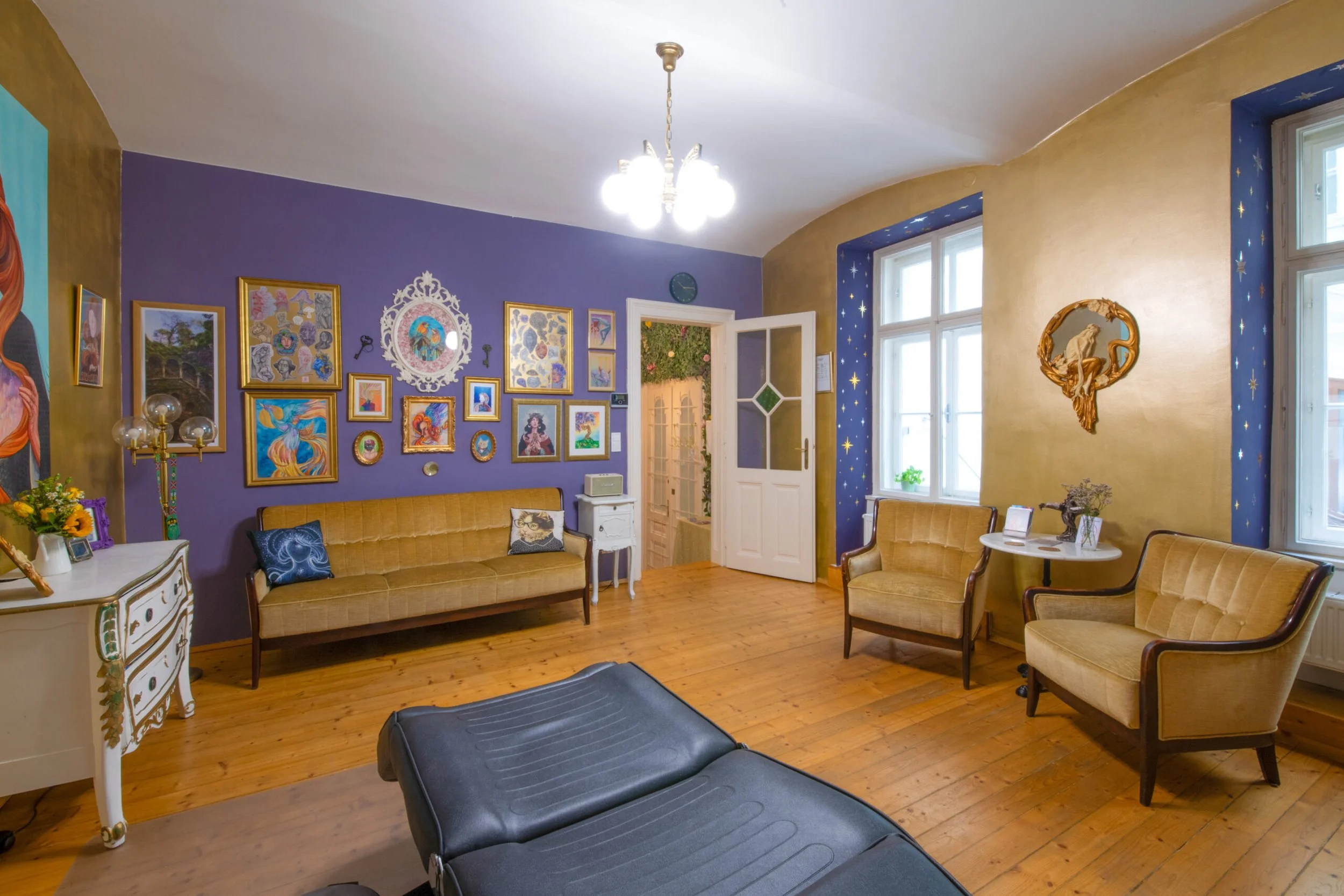 Tatuarium tattoo studio in Vienna, Austria room with purple and yellow walls, wooden flooring, vintage furniture, colorful wall art, and decorative items.