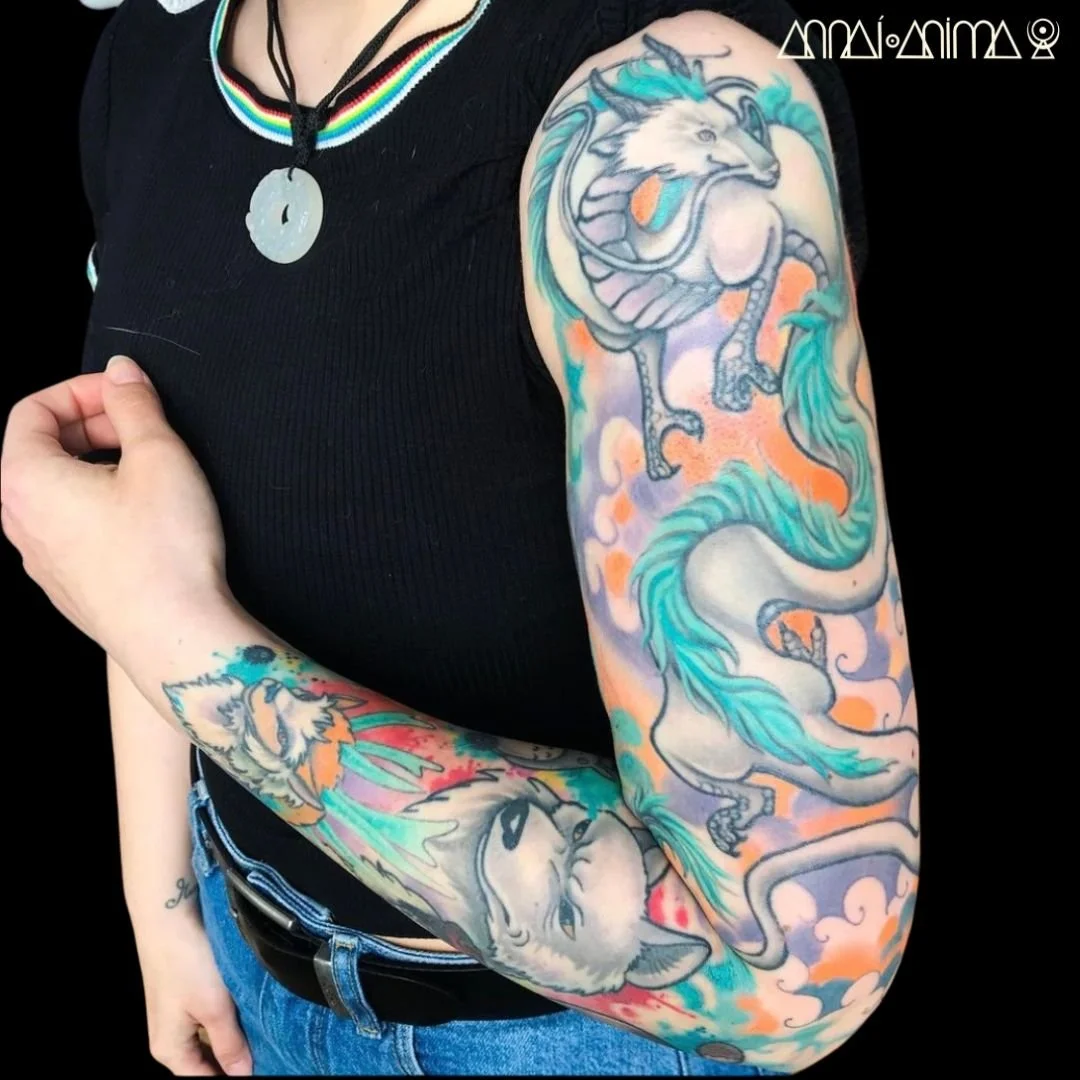 Colorful tattoos of a dragon and a wolf on a person's arm.