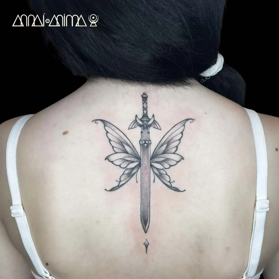 Tattoo on person's upper back of a sword with butterfly wings.