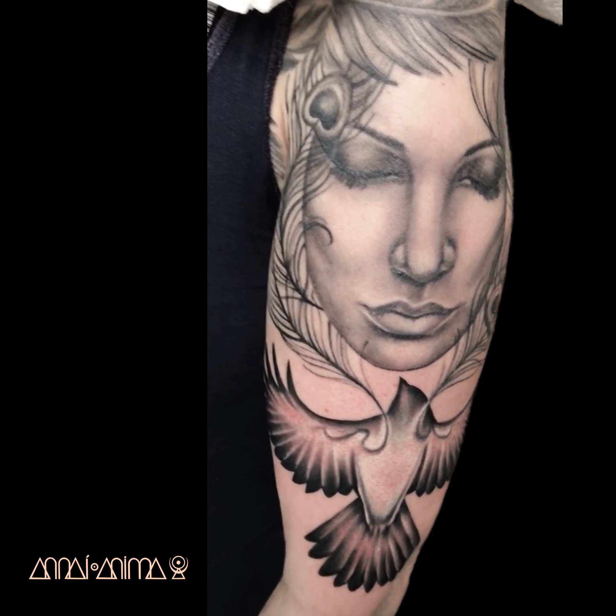 Tattoo of a woman's face with closed eyes and flowing hair, accompanied by a bird in flight at the bottom.