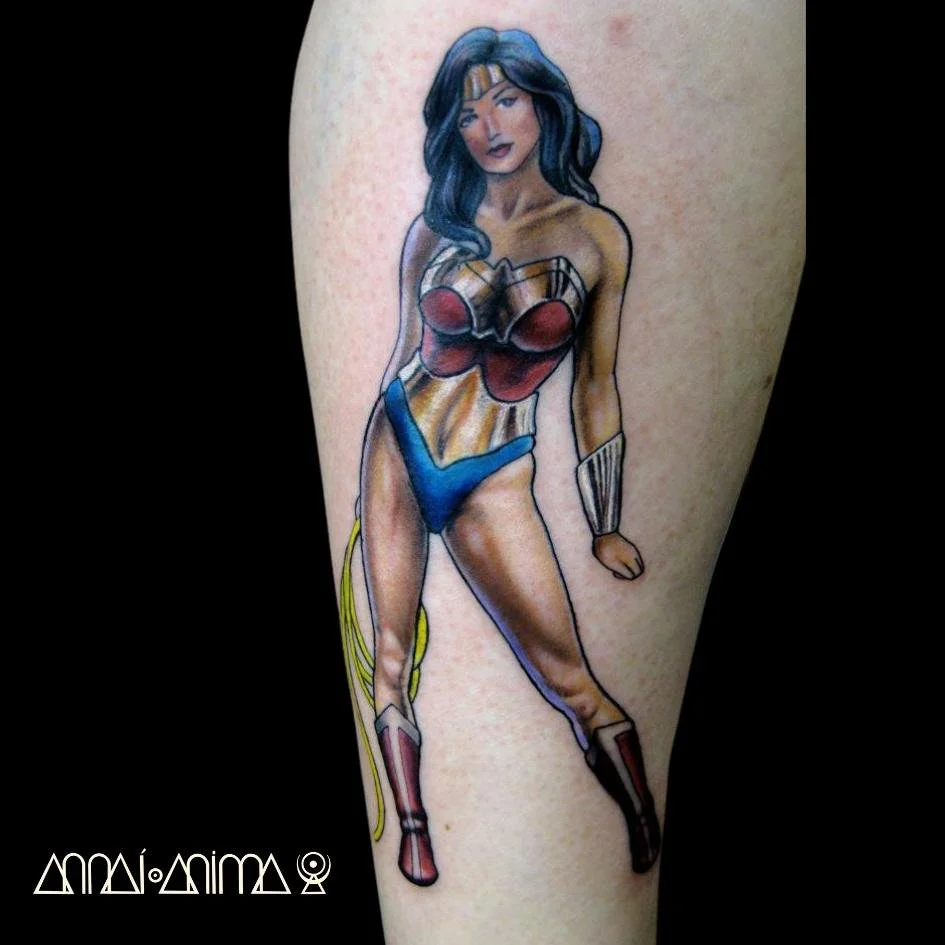 Colorful tattoo of a woman in vintage superhero costume on person's arm.