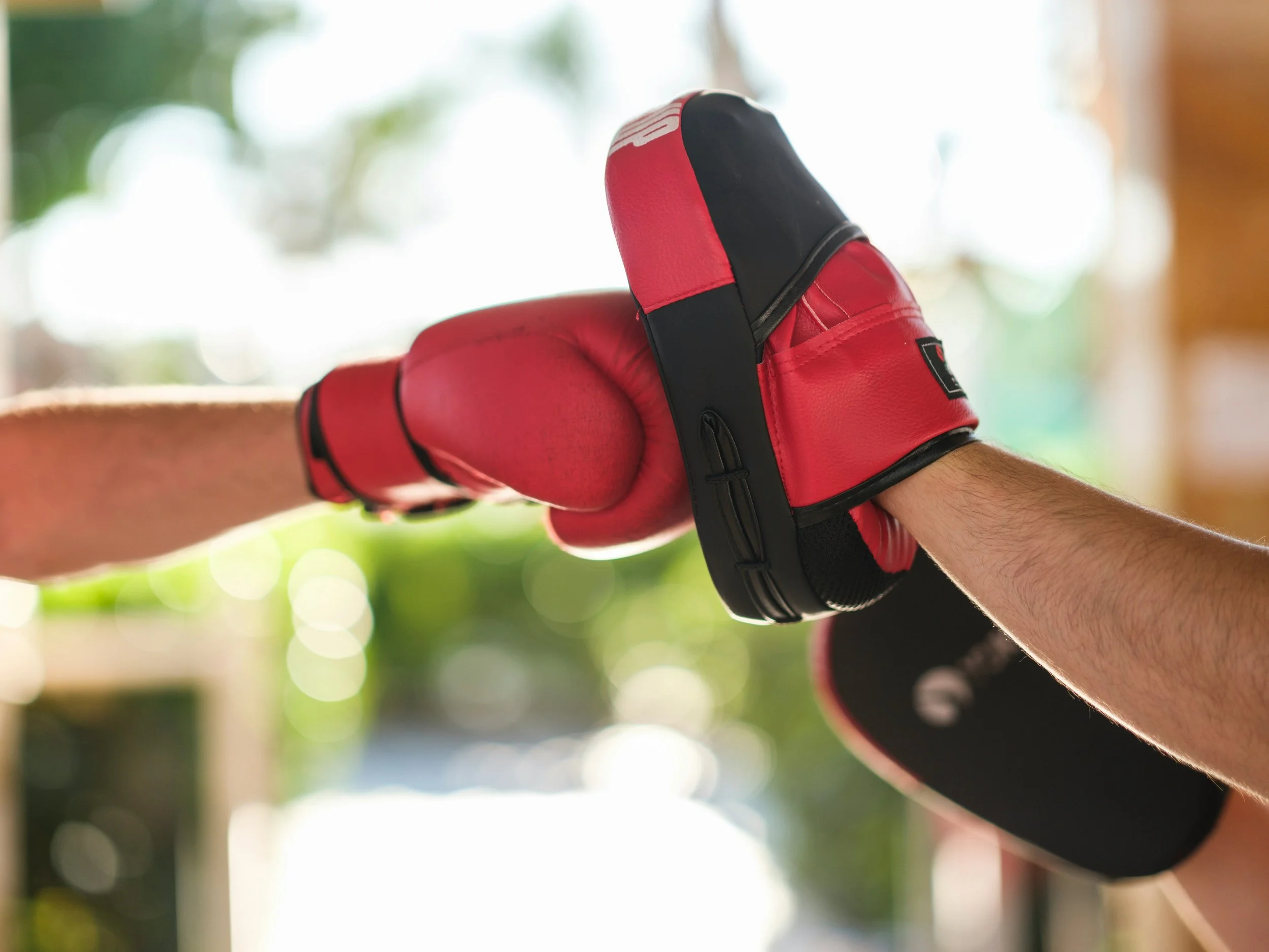 Twee mensen die een bokstraining doen met handschoenen en een bokszak.