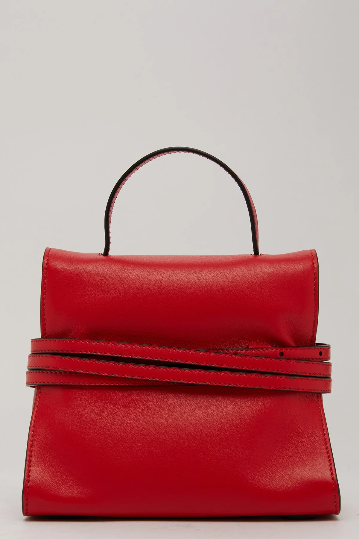 Sac à main rouge en cuir avec poignée noire et une longue sangle pliée autour de lui.