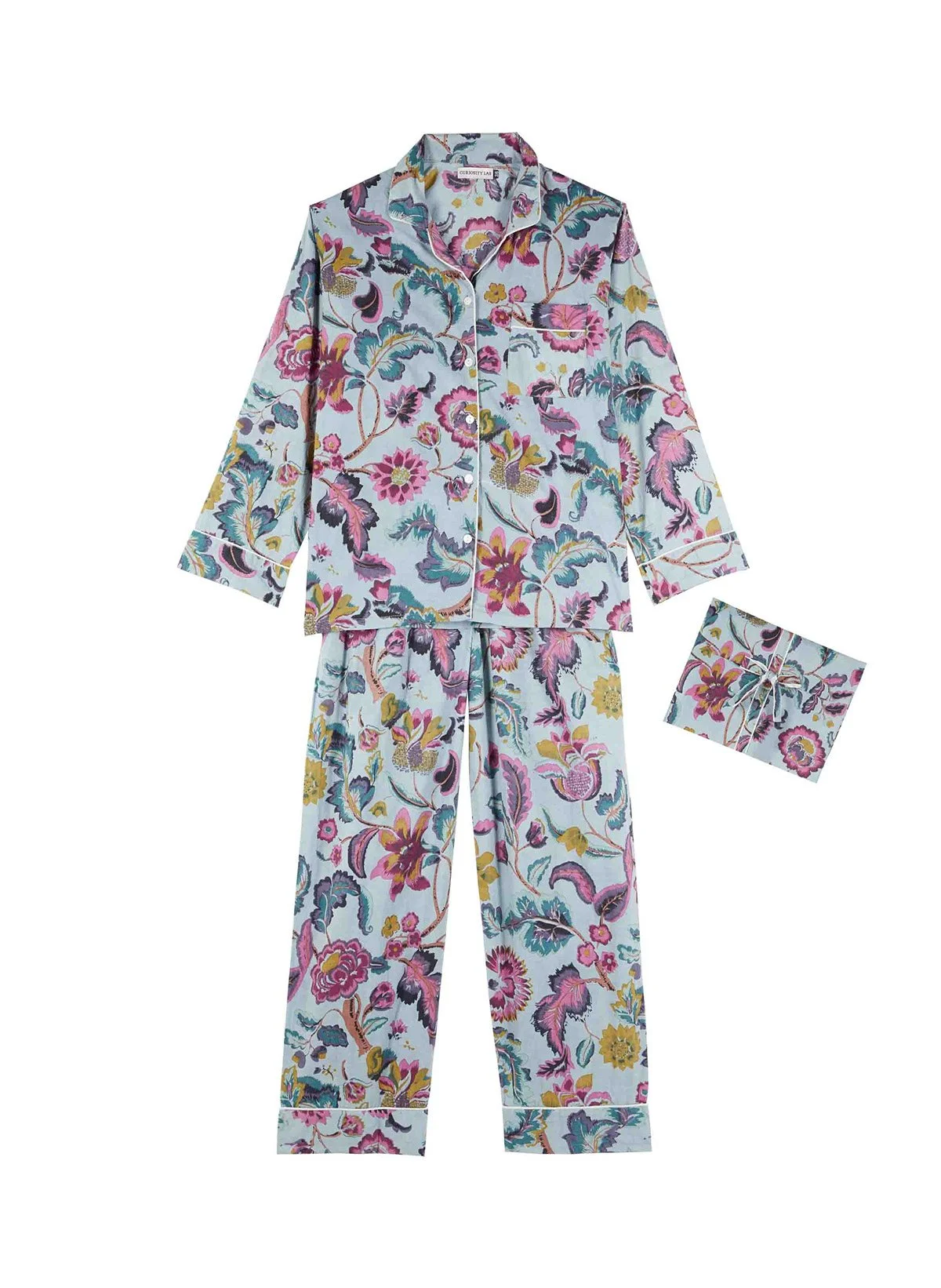 Pyjama à motifs floraux colorés comprenant une chemise et un pantalon, avec un paquet de pyjama plié à côté.