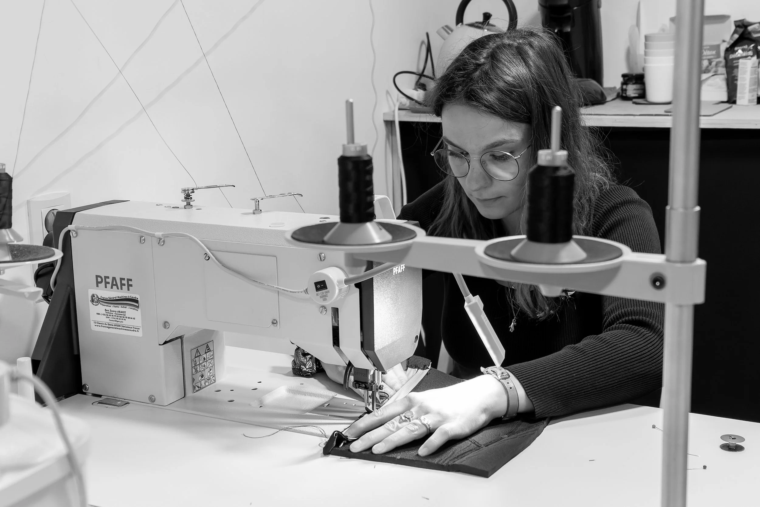 Femme travaillant sur une machine à coudre industrielle dans un atelier.