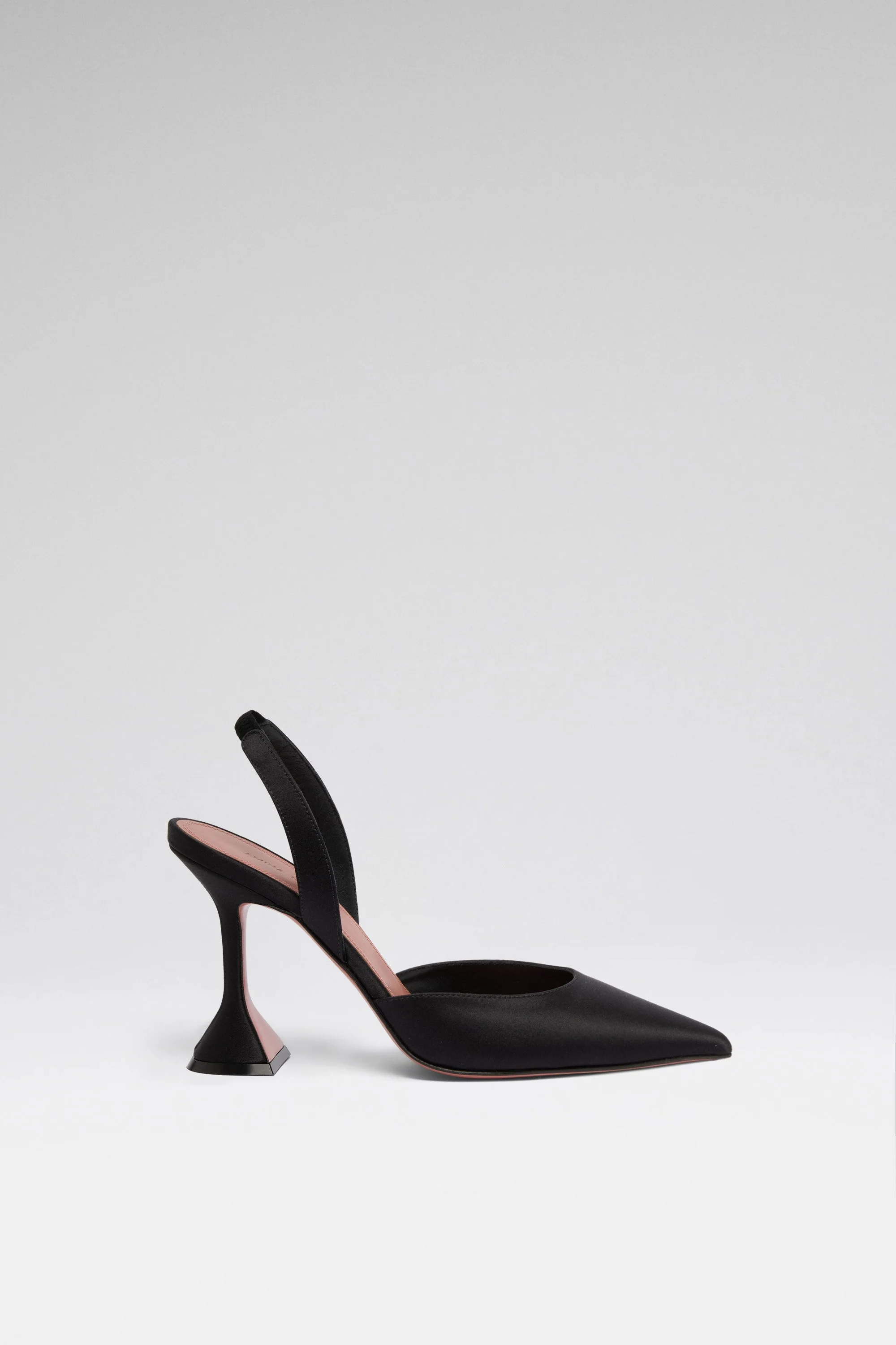 Chaussure à talon haut noir en cuir, avec une bride en satin noir, sur fond blanc.