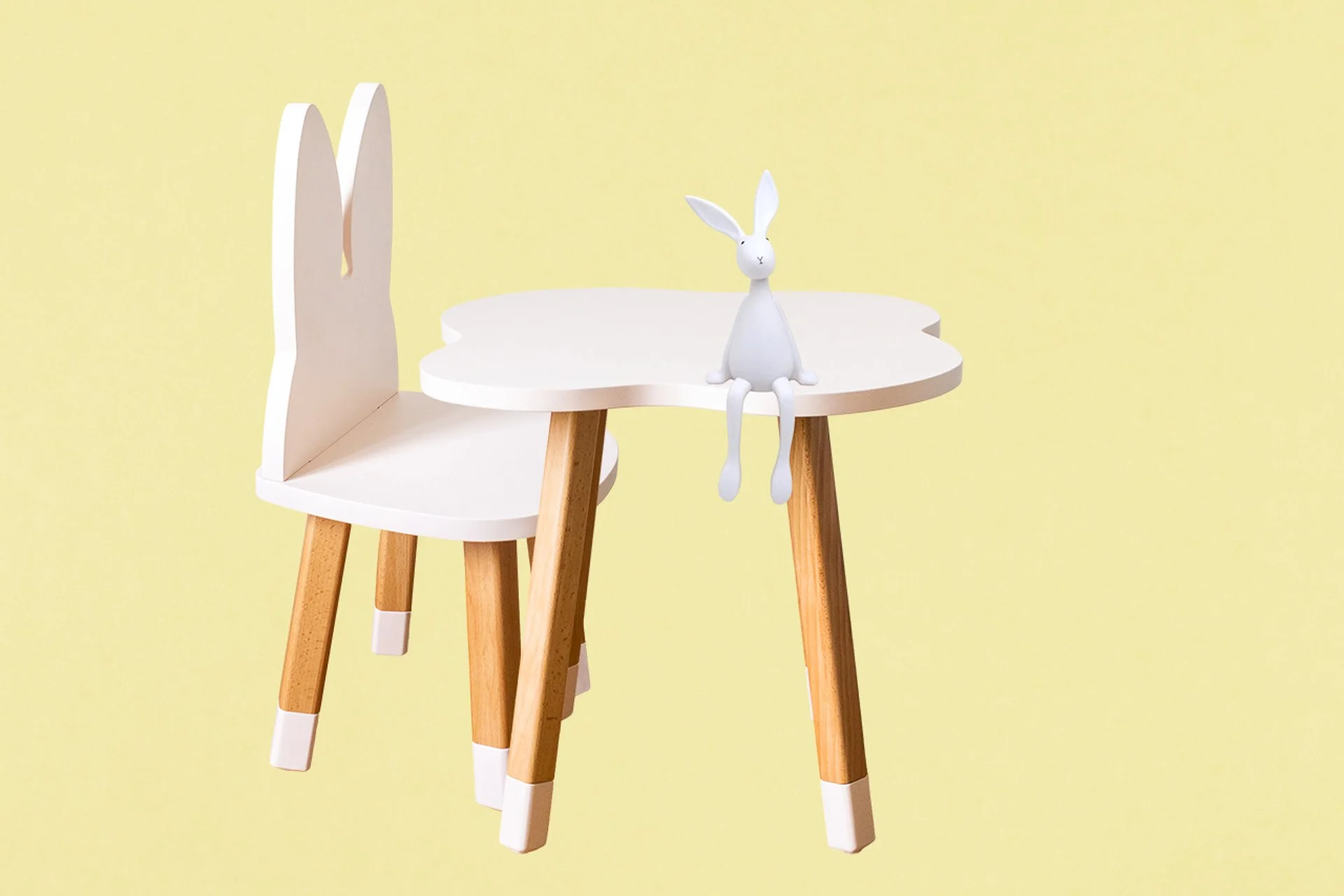 Un bureau pour enfant en forme de lapin avec un jouet lapin blanc assis dessus, fond jaune