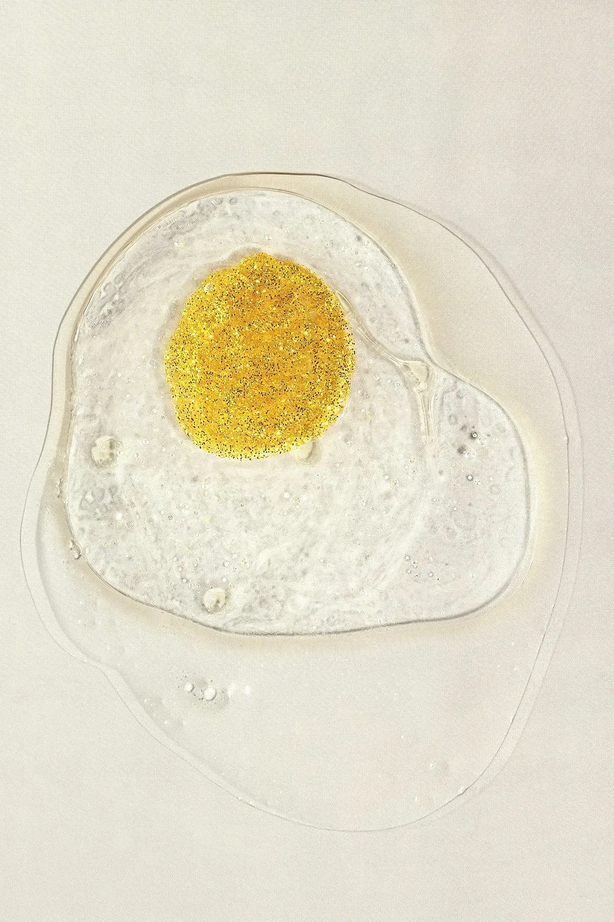 Une ovule humaine en macro, montrée en gros plan dans un environnement clair, avec présence de liquide autour.