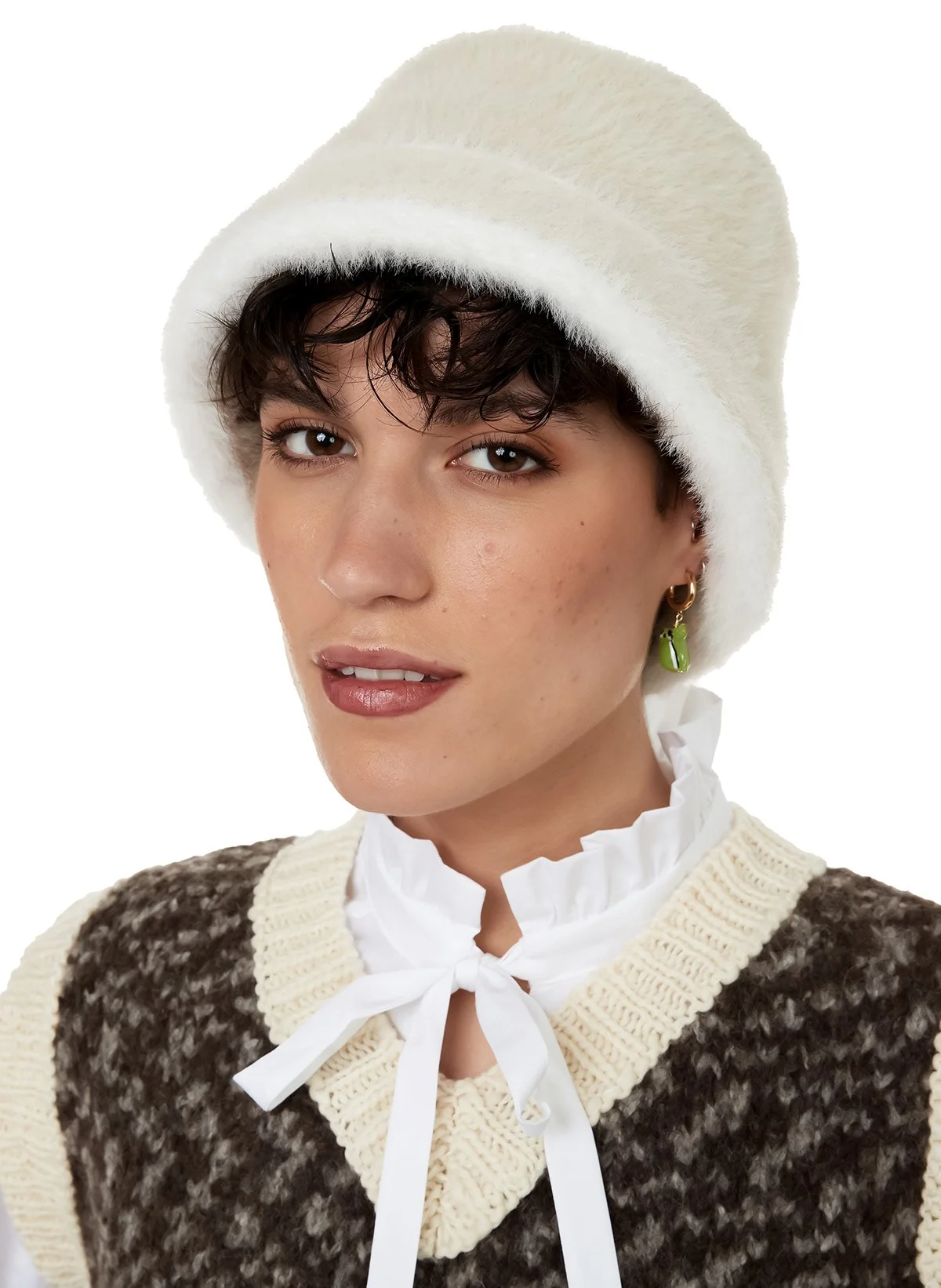 Jeune femme portant un bonnet blanc en fourrure et un pull tricoté marron avec des détails crème, avec un col blanc à nouer