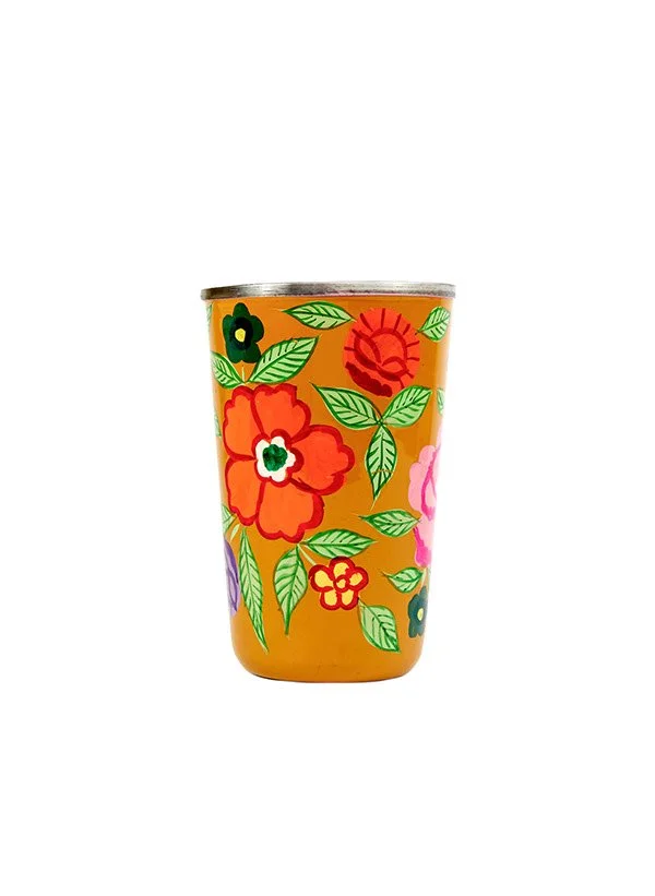 Tasse frappée avec un motif floral coloré, comprenant des fleurs et des feuilles vertes sur un fond doré.