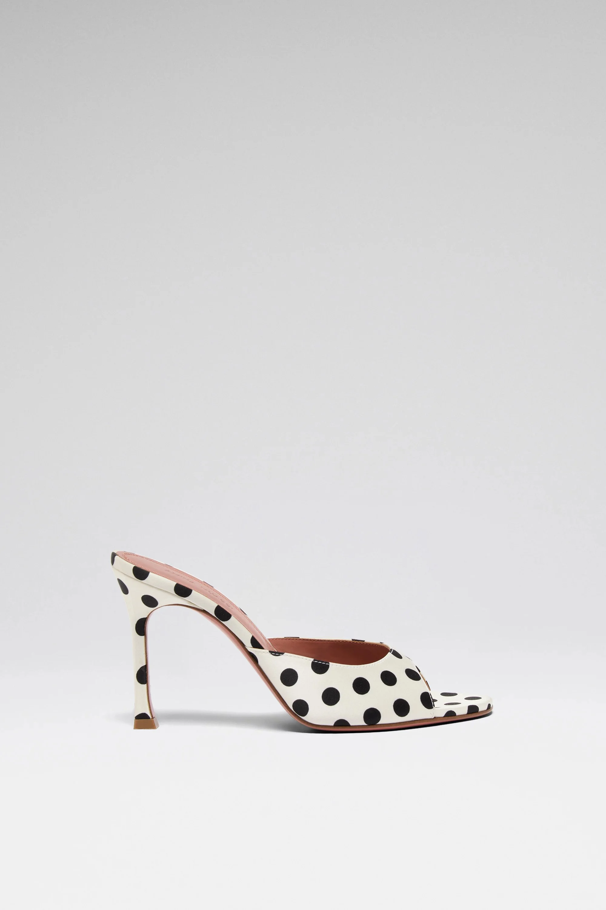 Chaussure à talon haut blanche avec pois noirs, intérieur rose, fond blanc