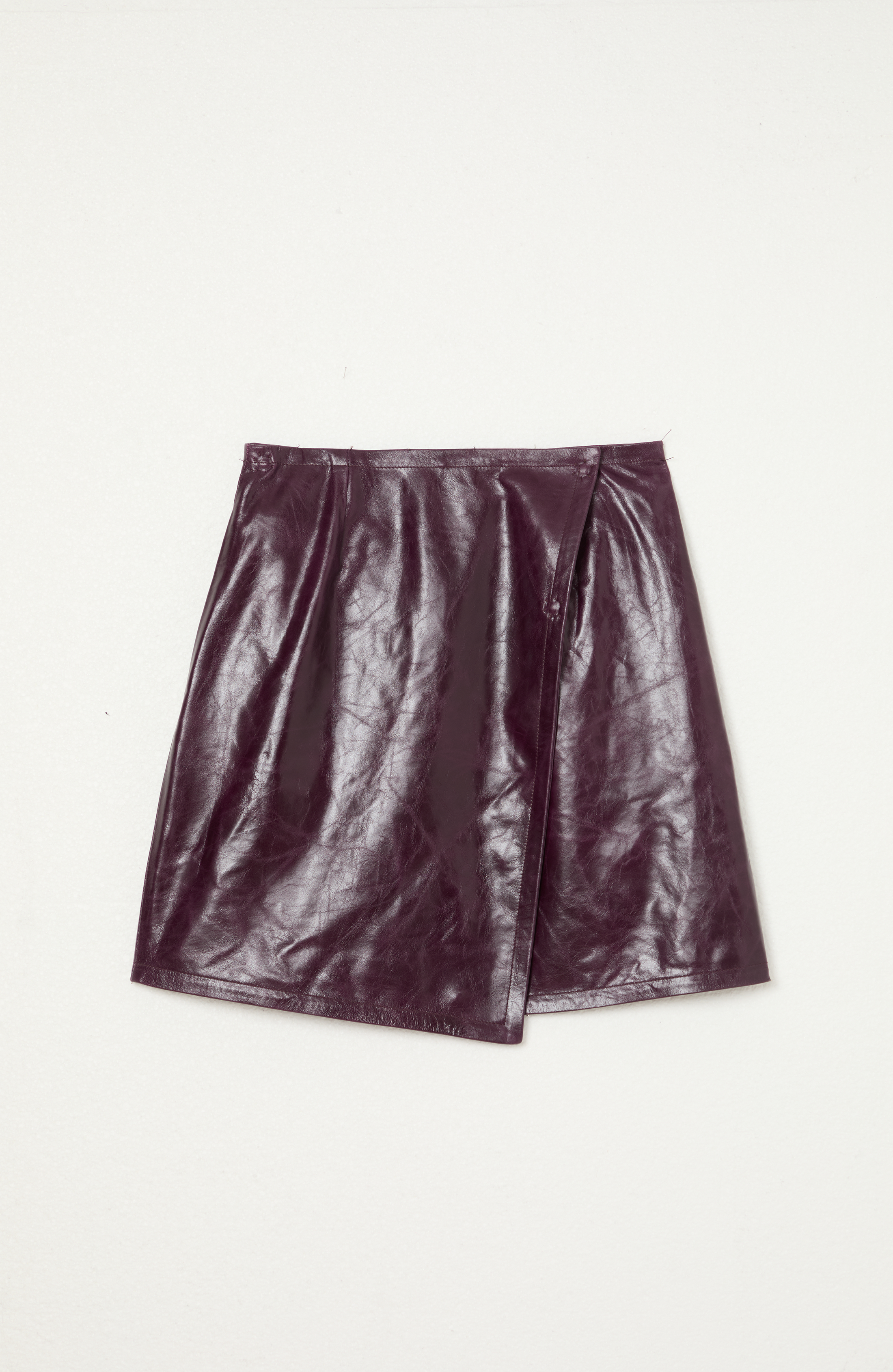 Jupe en cuir violet foncé sur fond blanc.