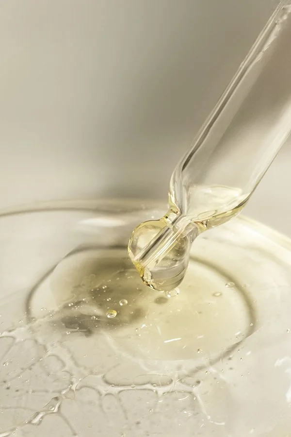 Une pipette en verre filtrant un liquide clair dans un récipient