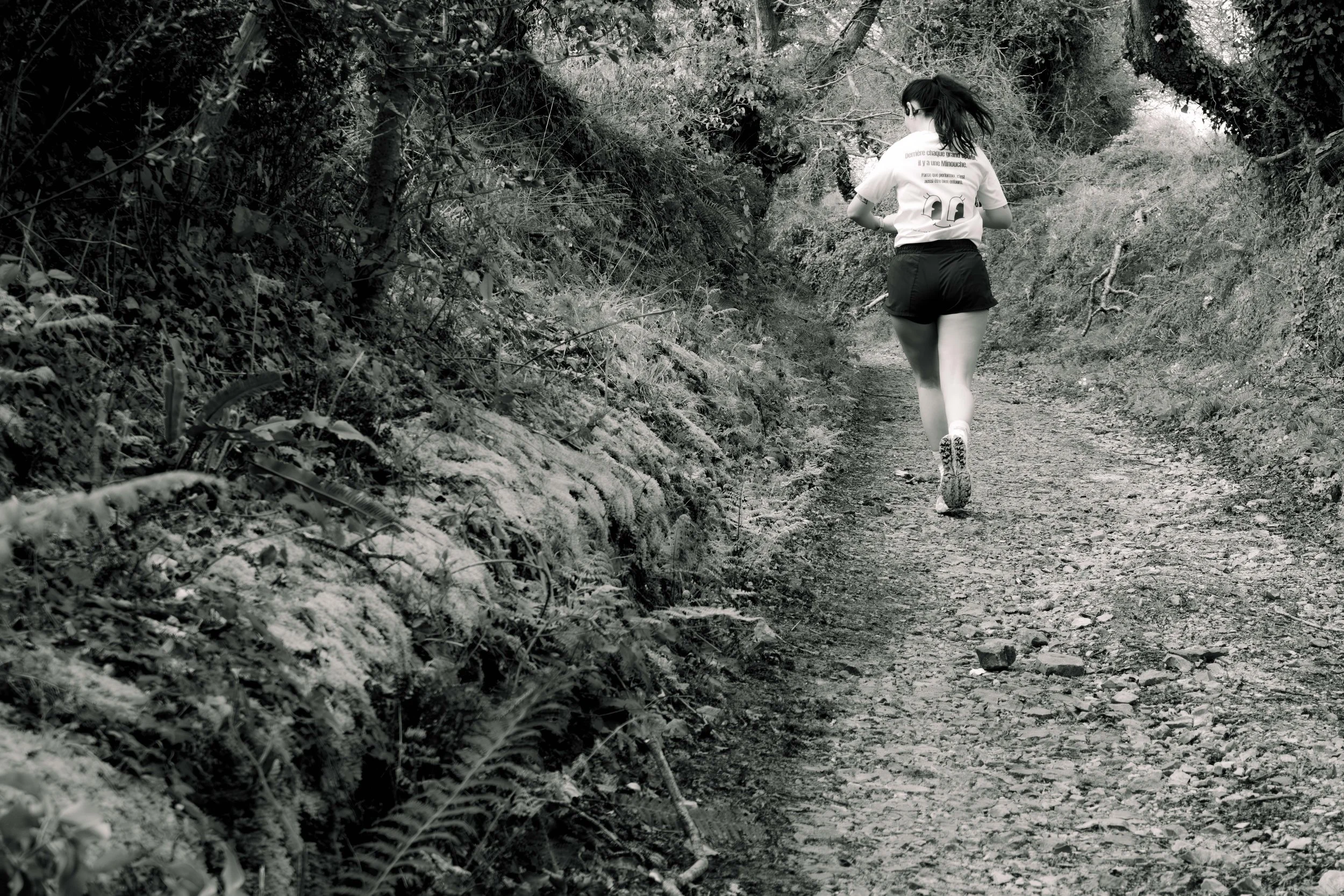 Une femme court sur un sentier en forêt