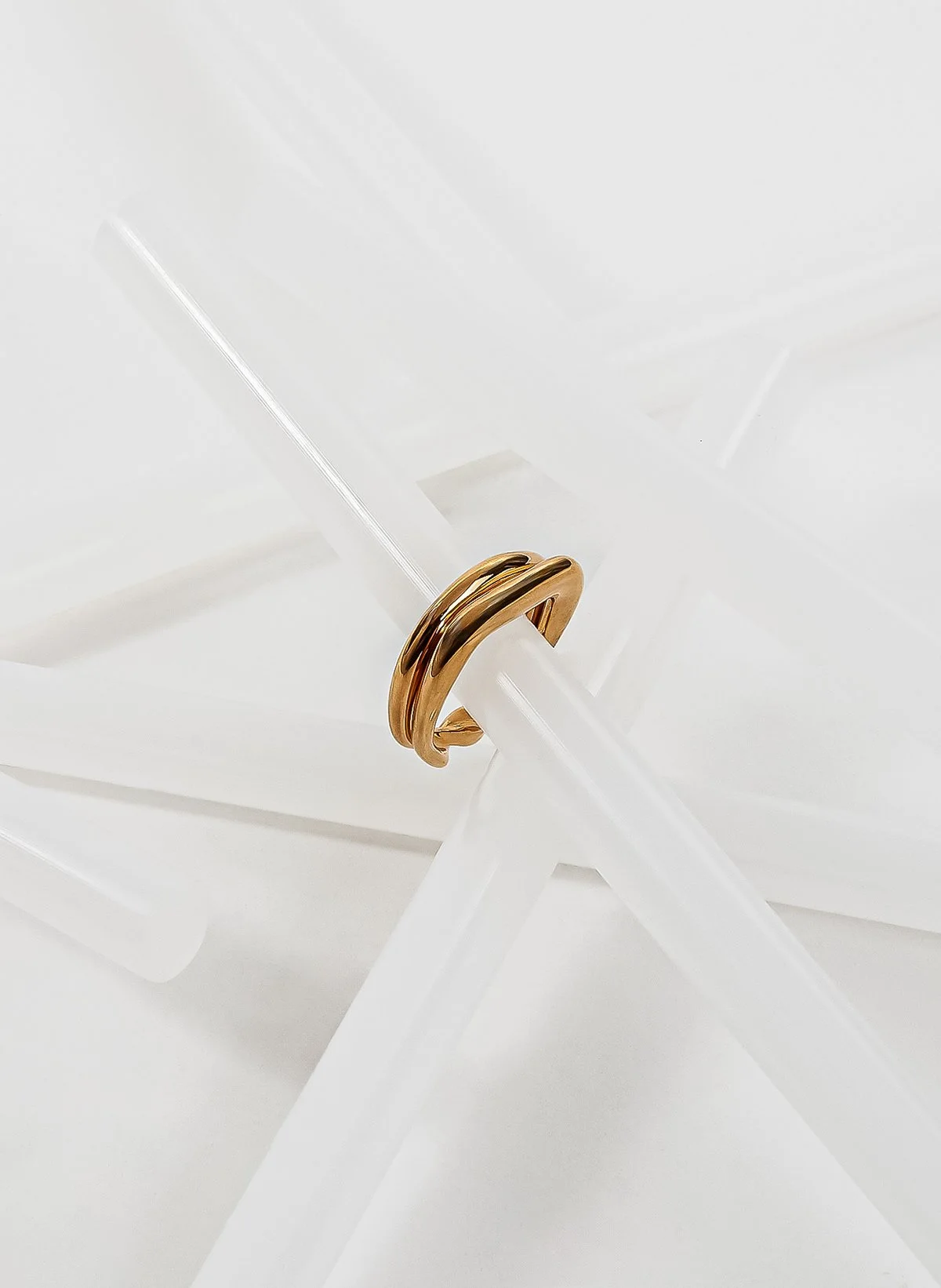 Anneau en or posé sur un support transparent