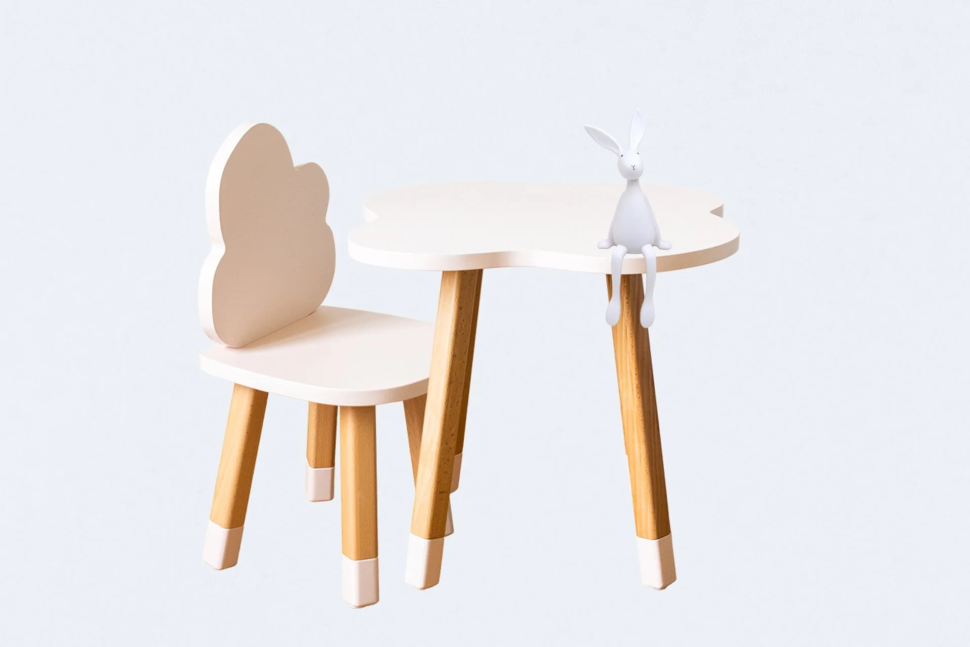 Une petite table avec un siège en bois, décorée d'un lapin blanc en plastique assis sur le bord.