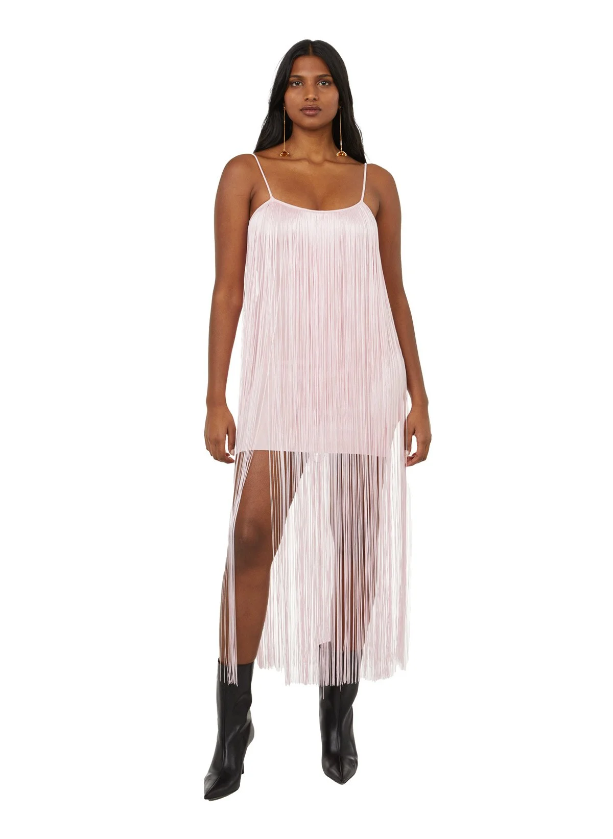 Femme portant une robe longue en tissu plissé rose pâle avec un décolleté carré et des bretelles minces, avec des bottines noires.