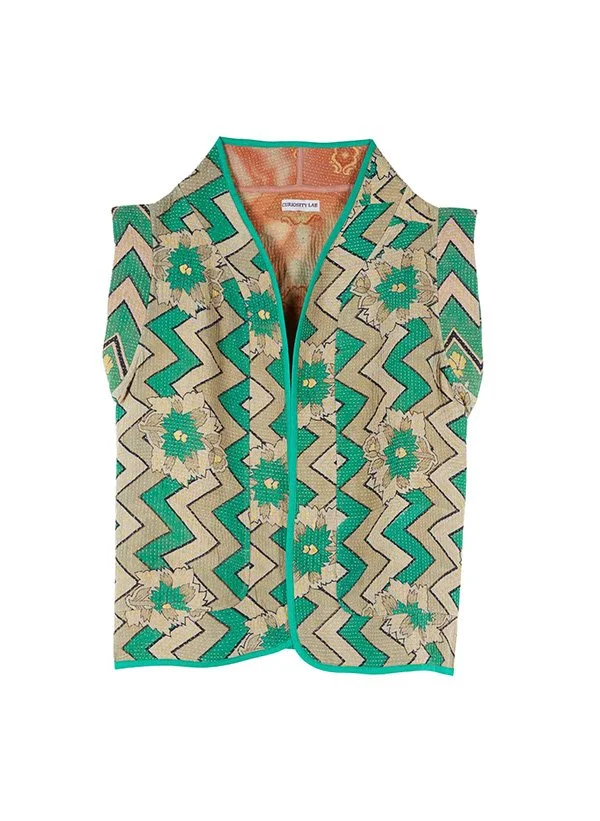 Gilet sans manches à motif géométrique avec fleurs en vert, beige et bleu, avec une fermeture éclair au centre.