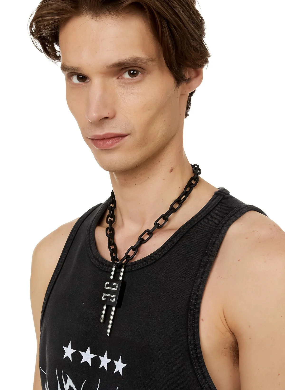 Jeune homme portant un débardeur noir et un collier épais noir avec une médaille suspendue, look moderne.