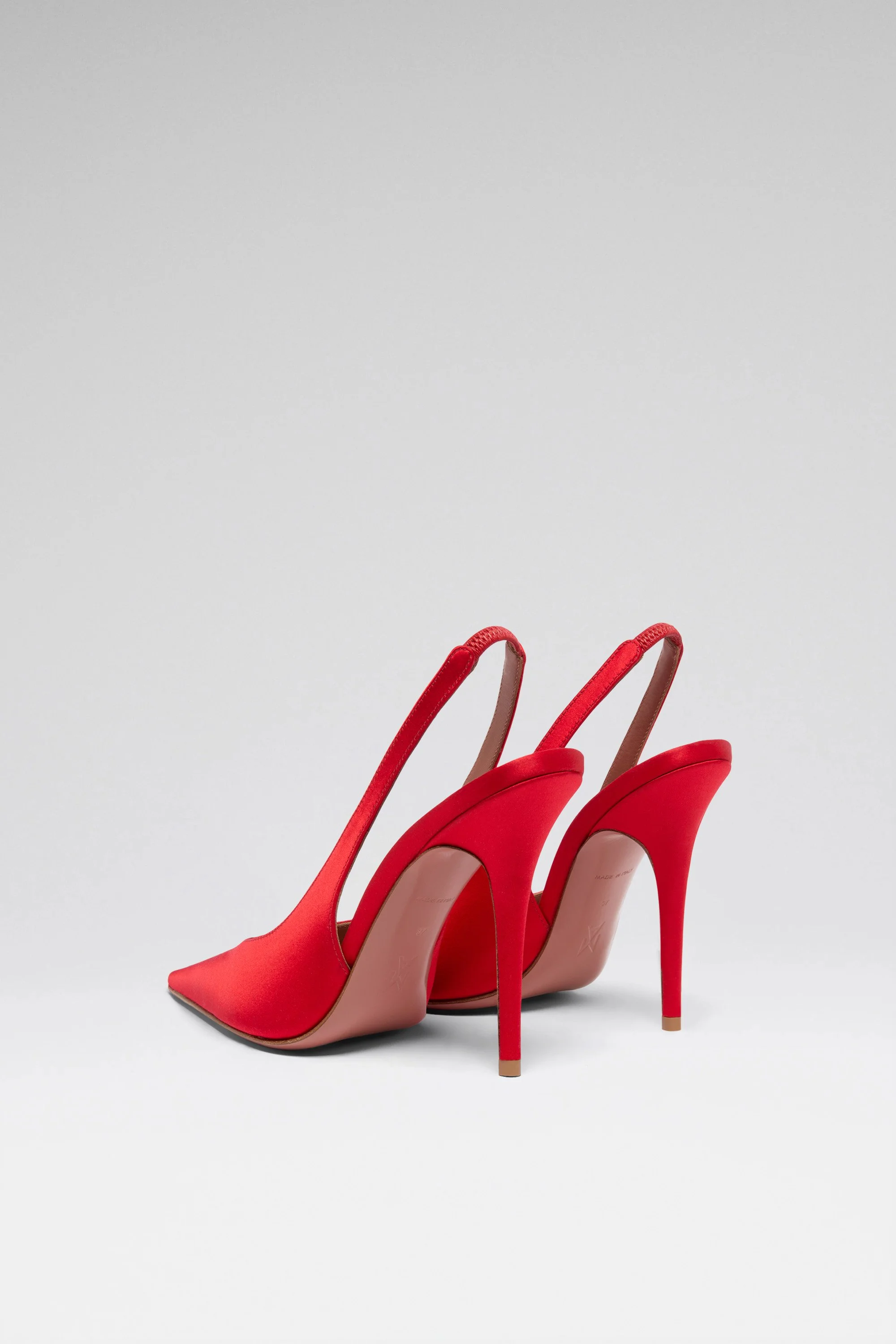 Chaussures à talons rouges avec talons fins et brides à l'arrière, vue de côté, sur fond blanc.