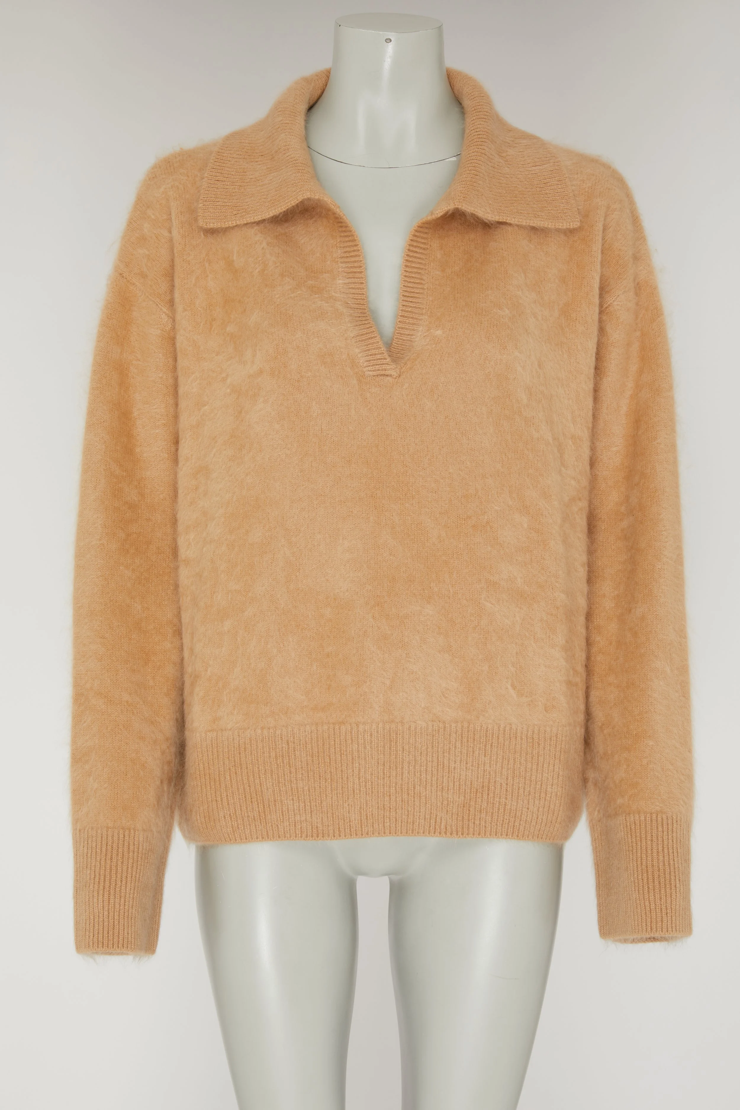Pull beige en laine porté sur un mannequin en plastique.