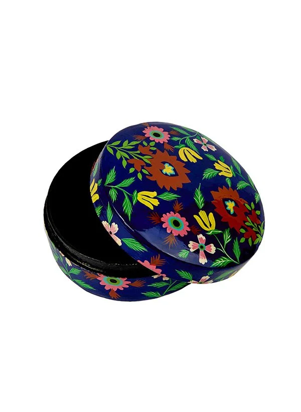 Boîte ronde avec un motif floral coloré sur fond bleu, avec le couvercle légèrement ouvert.
