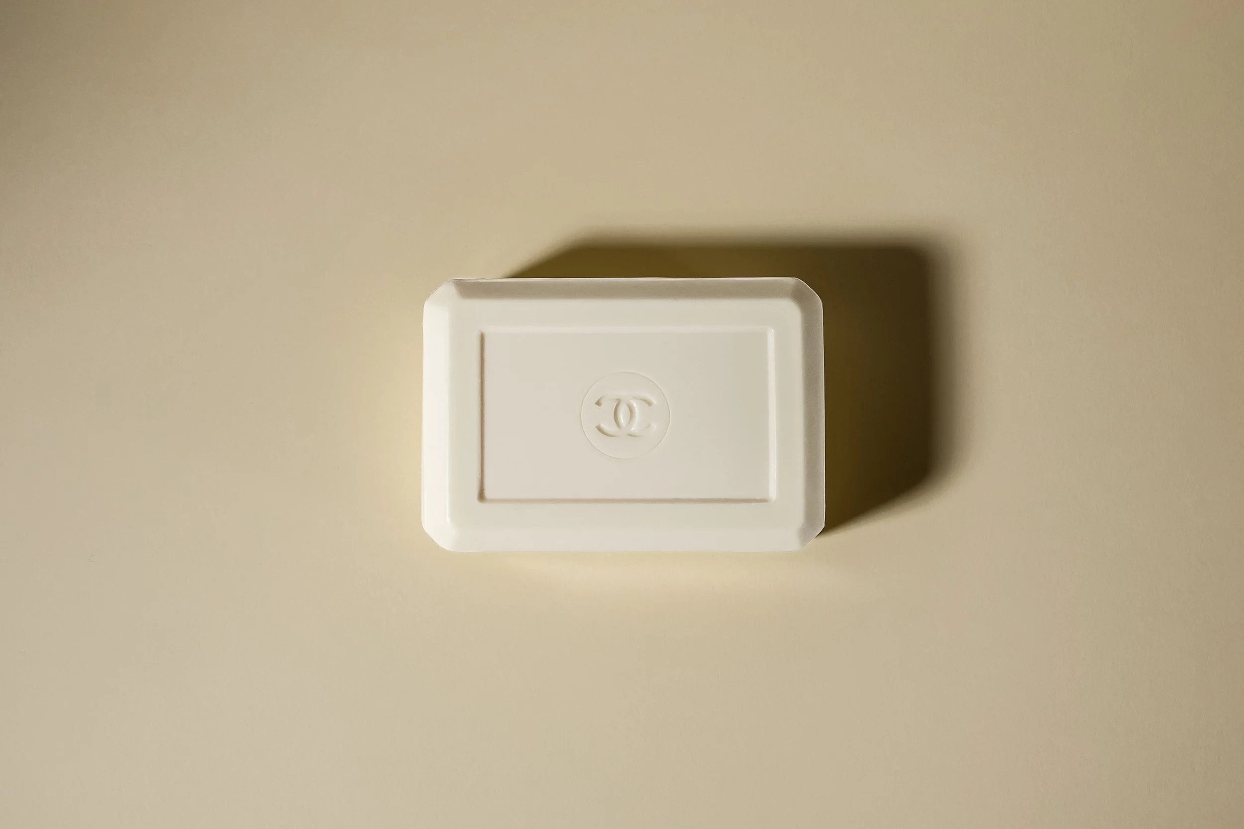 Boîte blanche avec le logo Chanel en relief dessus, vue du dessus, avec ombre portée.