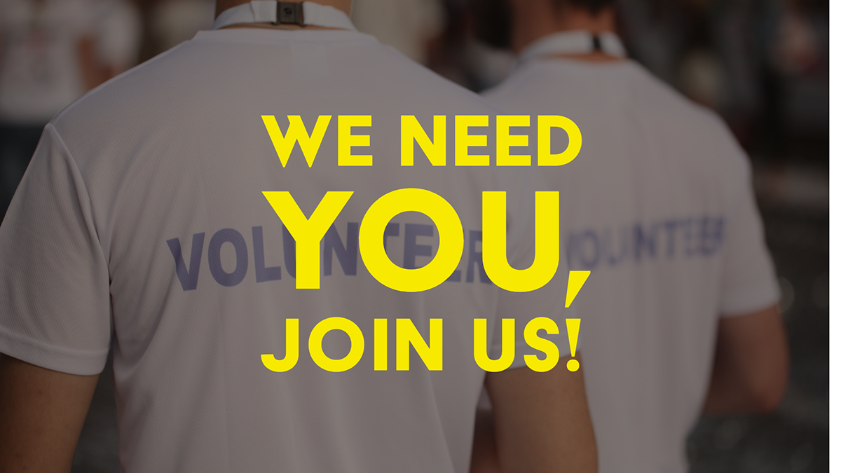 Gens portant des t-shirts de bénévolat avec le message "We need YOU, join us" en jaune sur un fond flou