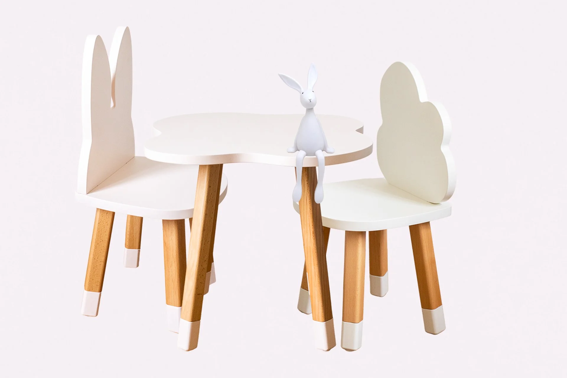 Deux chaises en forme de lapin avec un tableau blanc entre elles, et une figurine de lapin assise sur le tableau.