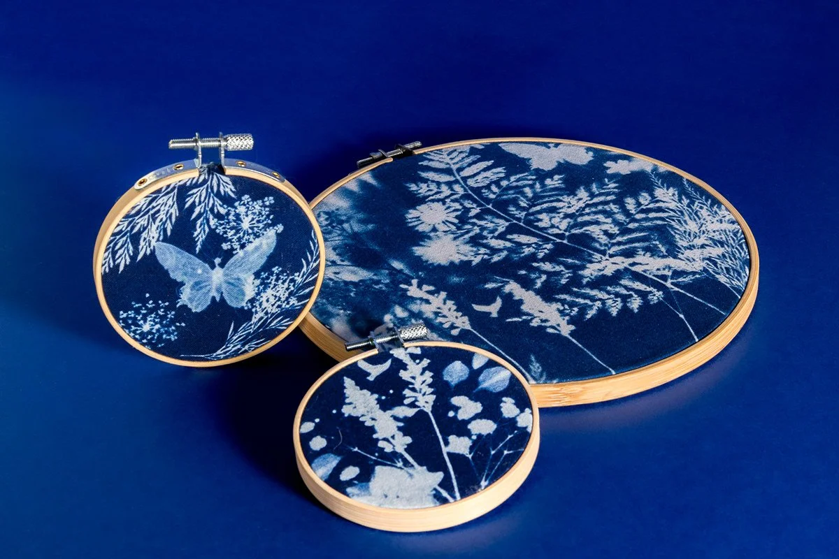 Coffrets de broderie avec des motifs de nature en bleu et blanc, comprenant une boucle d'encadrement, un cadre de machine à broder et un petit cercle de broderie.