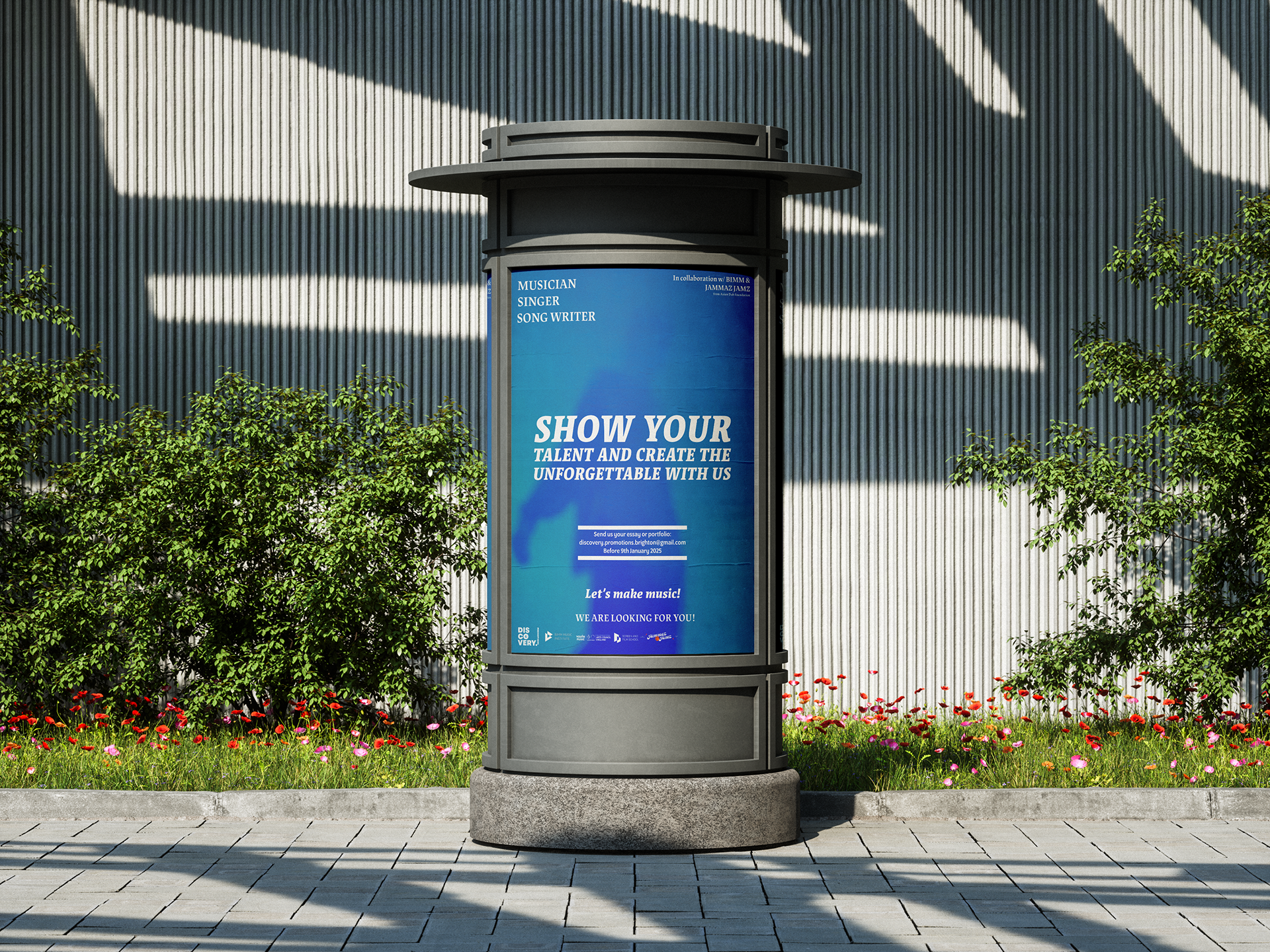 Une affiche bleue sur un stand d'affichage extérieur invitant les musiciens, chanteurs et écrivains de chansons à montrer leur talent, avec des instructions pour envoyer leur essai ou portfolio, sous un mur en métal avec des arbres et des fleurs au p