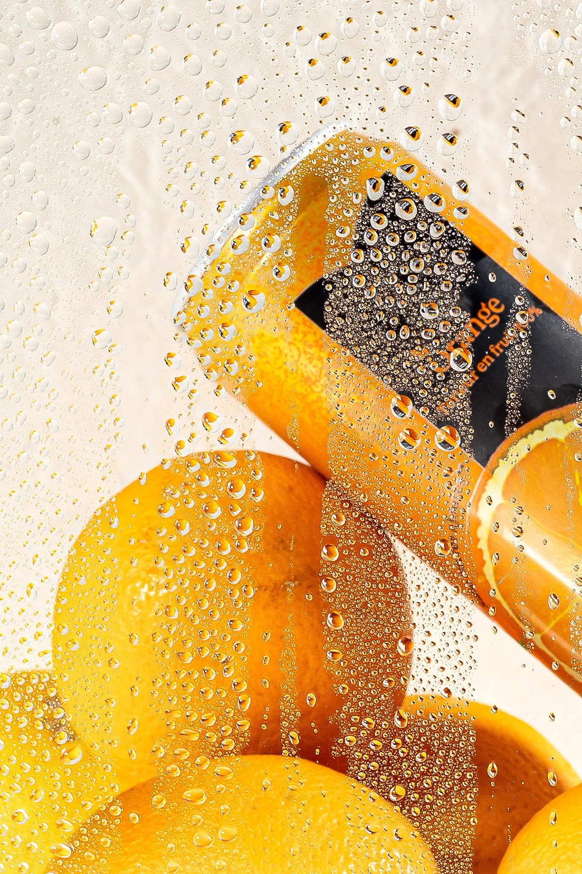 Citron står derrière une vitre mouillée avec des gouttes d'eau, vue en gros plan, avec une bouteille d'orangeade à l'arrière-plan.