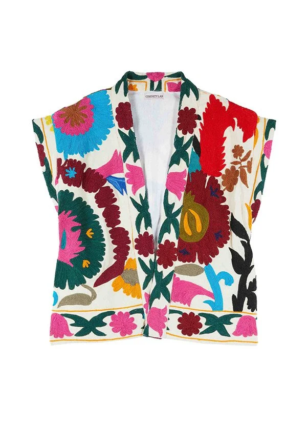 Veste sans manches avec motif floral multicolore sur fond blanc.