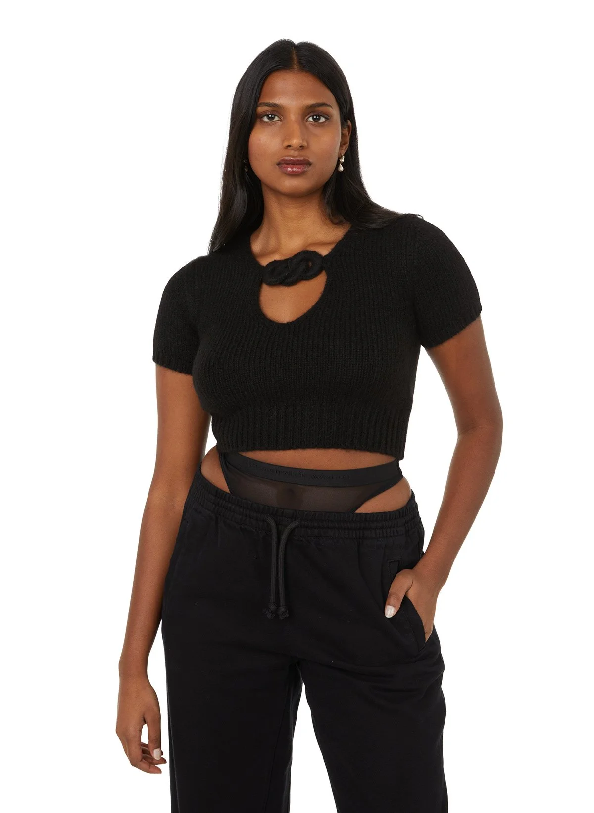 Une femme portant un haut noir à manches courtes, un pantalon jogging noir et un sous-vêtement transparent