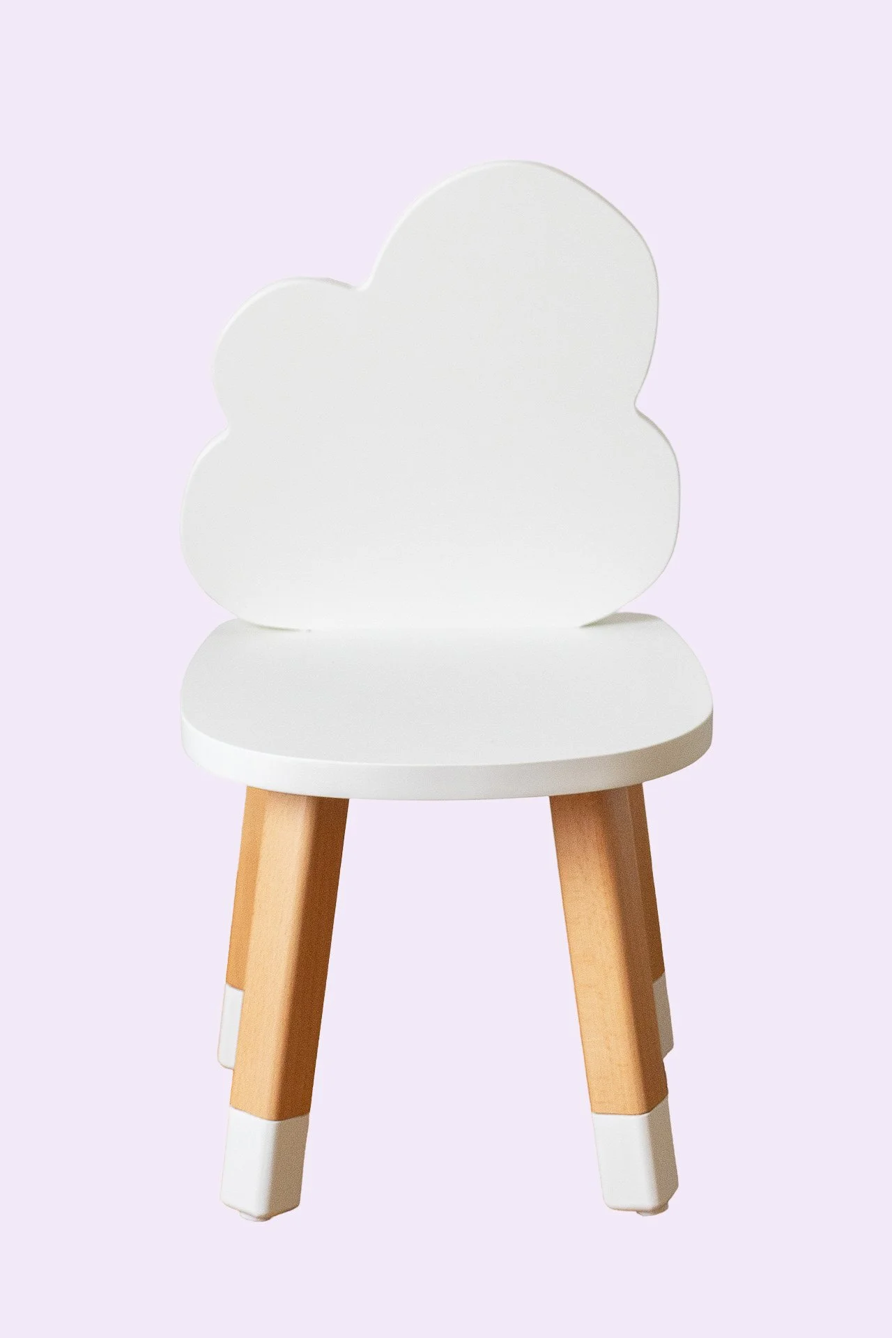 Chaise d'enfant avec une assise blanche et un dossier en forme de nuage, pied en bois naturel, fond violet clair.