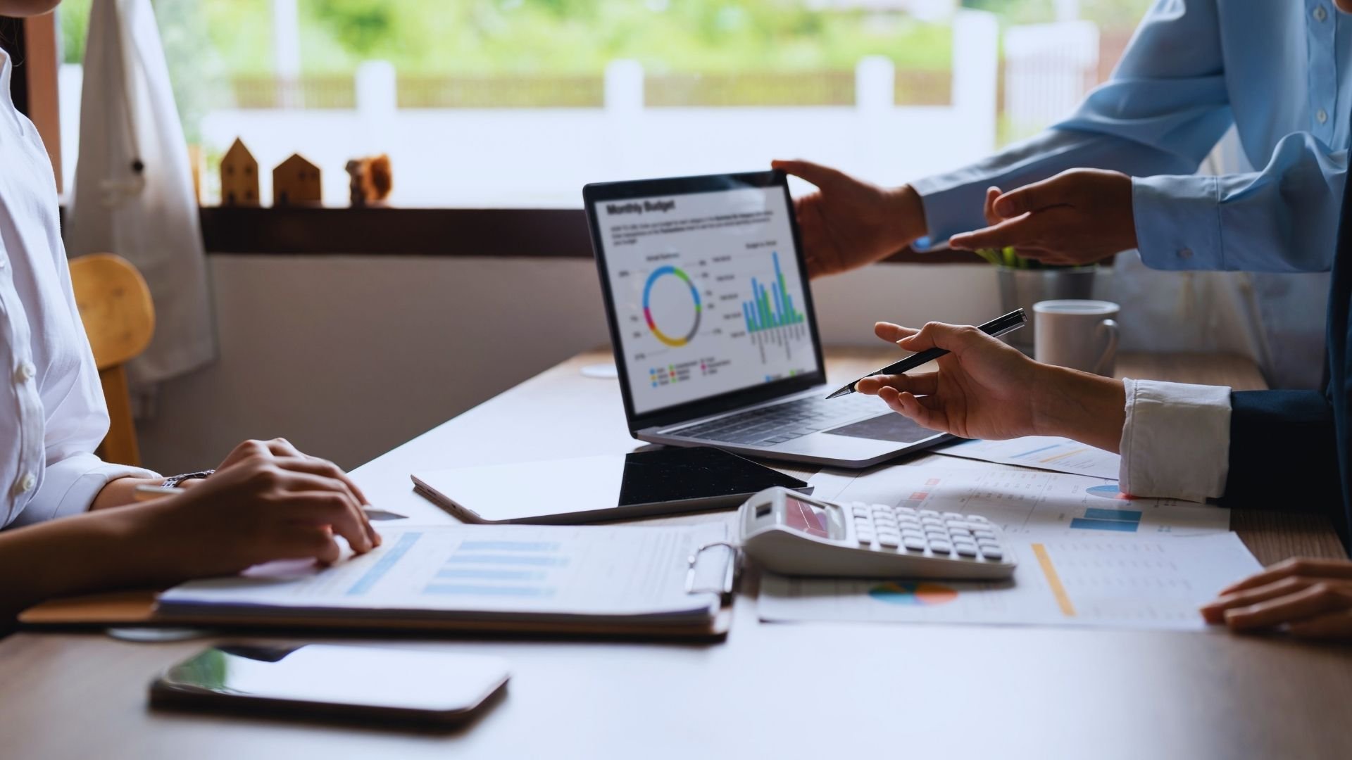 Accounting professionals reviewing financial reports and business performance data during a client advisory meeting.