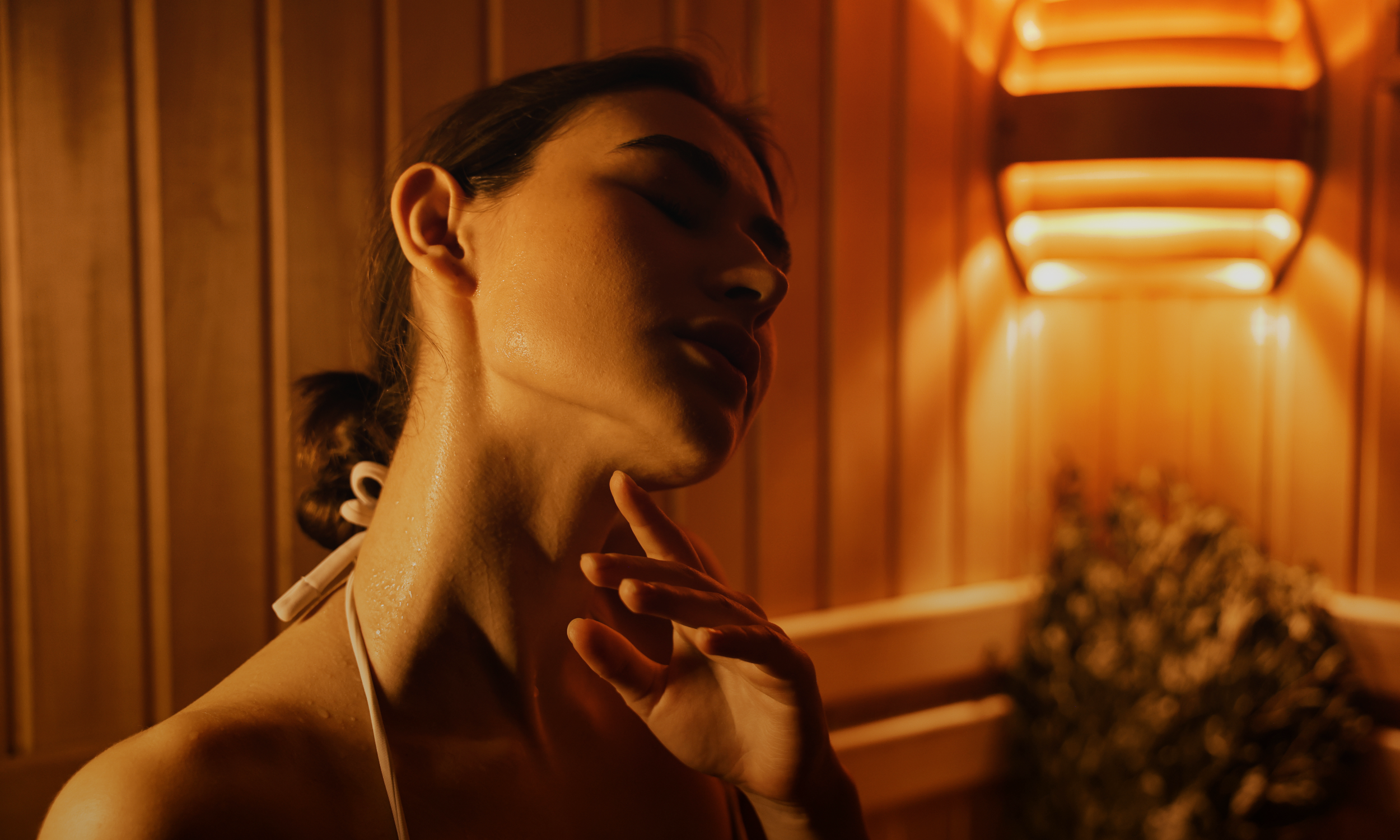 woman sitting in heat and steam of sauna enjoying essential oils and aufguss experience