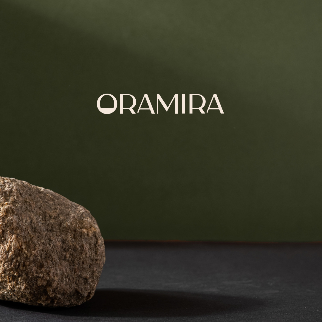 A brown rock on a dark background with the word "ORAMIRA" in white text.