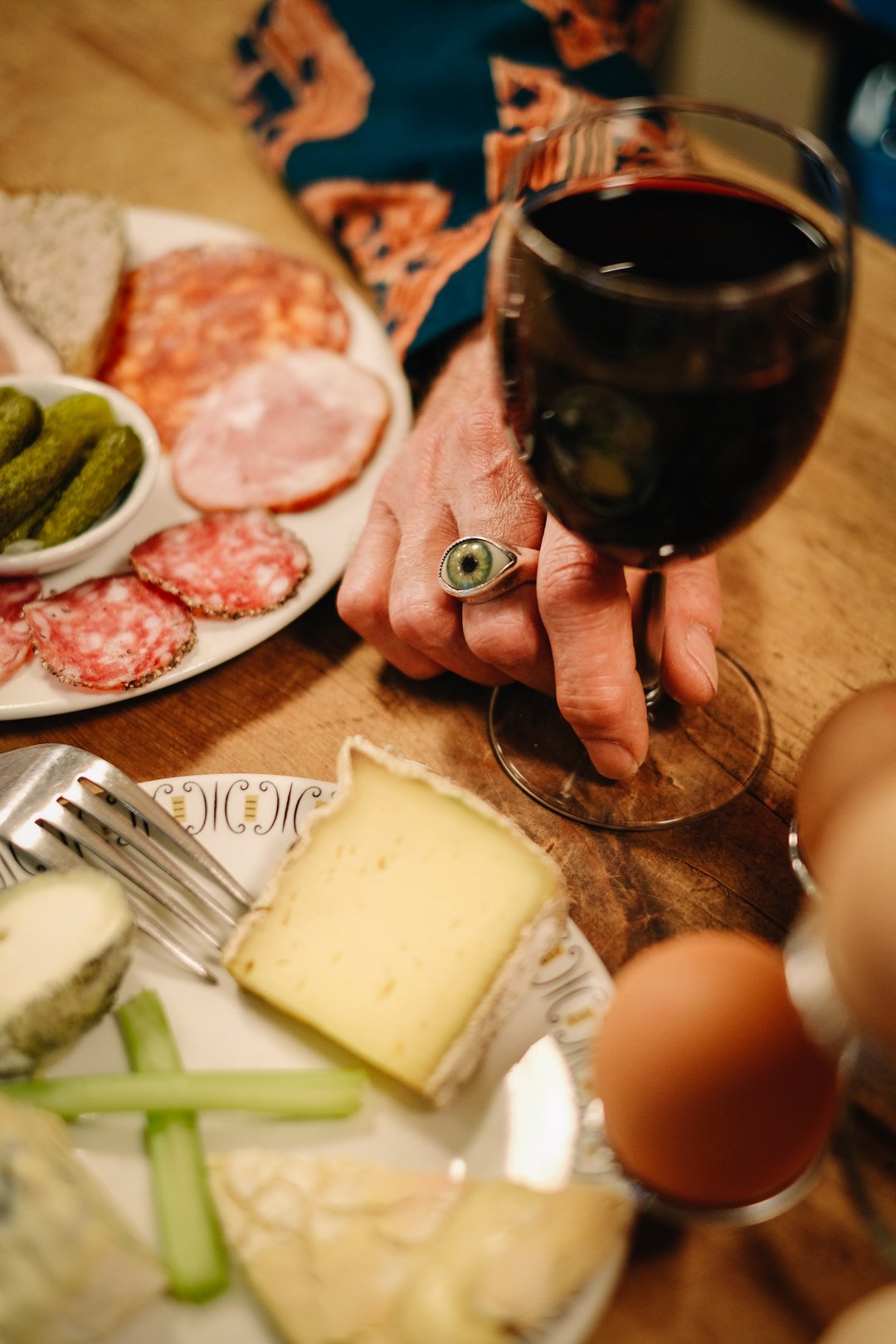A French cheese and charcuterie board served with a glass of red wine in a traditional Soho setting.