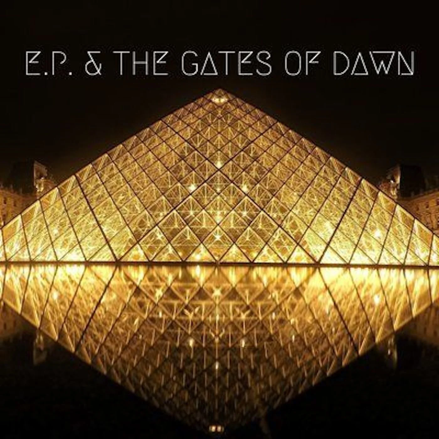Nighttime view of a illuminated glass pyramid structure with the text 'E.P. & THE GATES OF DAWN' at the top.