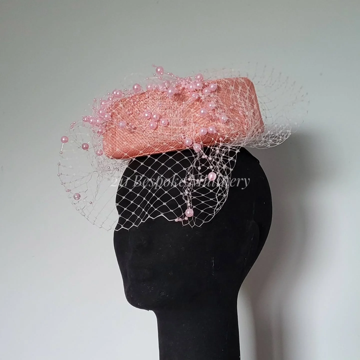 ❤️Now Available❤️

A classic timeless design ~ a modernisation of the 1960s pillbox hat. Vintage all the way. 

Featuring a gorgeous peach pink sinamay, this piece was a triumph for the hat block I made by hand. 

A lovely sea of white veiling cascad
