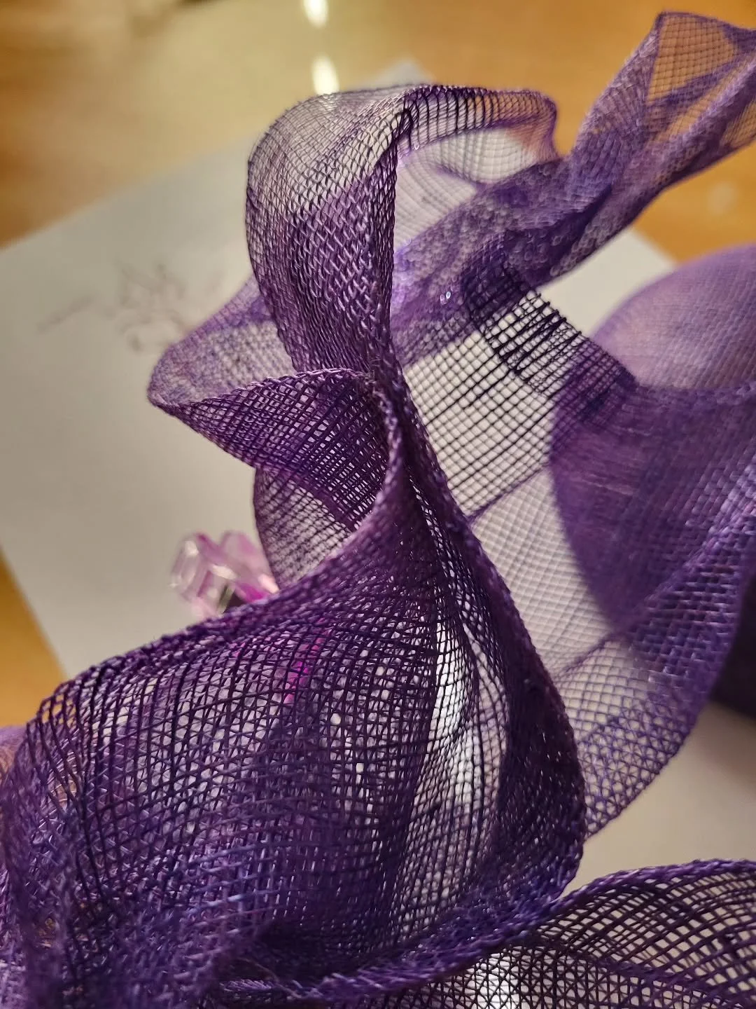 🪡A working shot on the newest piece I have on the studio table ~ 

The fabulous button will be adorned with this hand shaped and steamed panel of sinamay ~ which so far has some gorgeous hand formed curves and ripples. A very organic occurance betwe