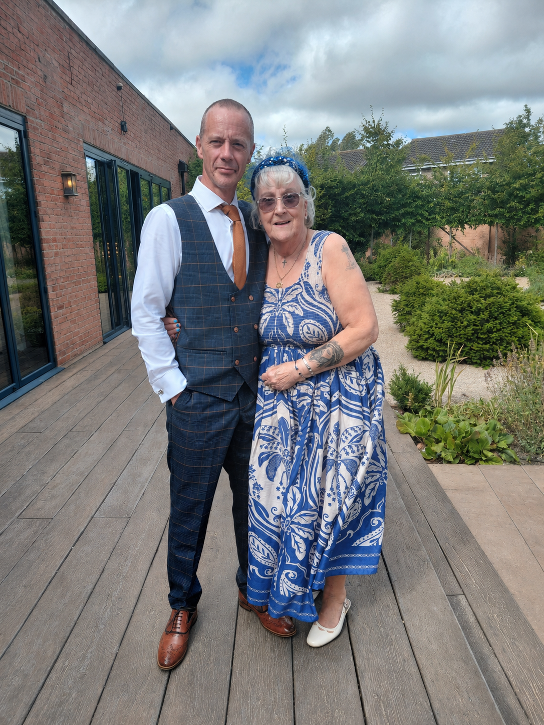 A lovely nana of the groom alongside her son, the father of the groom, sporting a dazzling custom embellished head band. 
